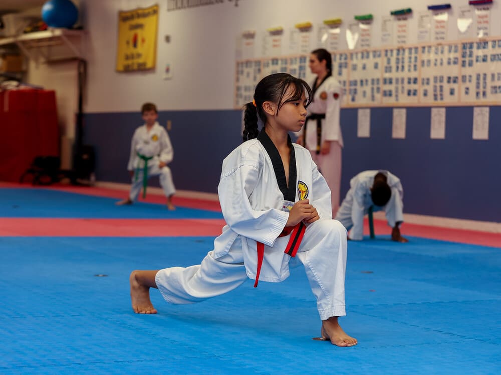 a kid with red belt doing a warm up before her taekwondo class in Norristown PA