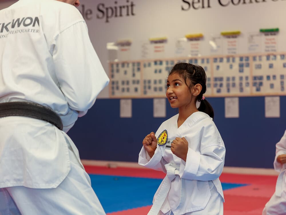 a kid with white belt practicing taekwondo with her master in Norristown PA
