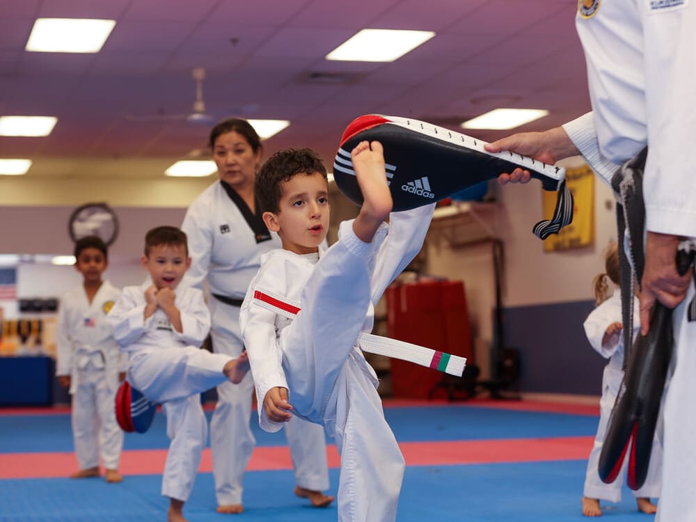a group of kids practice taekwondo kicking with their instructor during little ninja session in Norristown PA