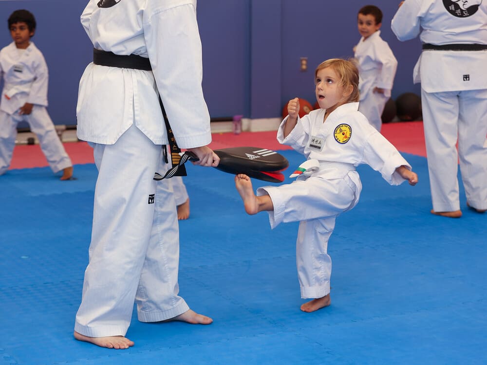 a young girl practice taekwondo kicking with her instructor during her session in Norristown PA